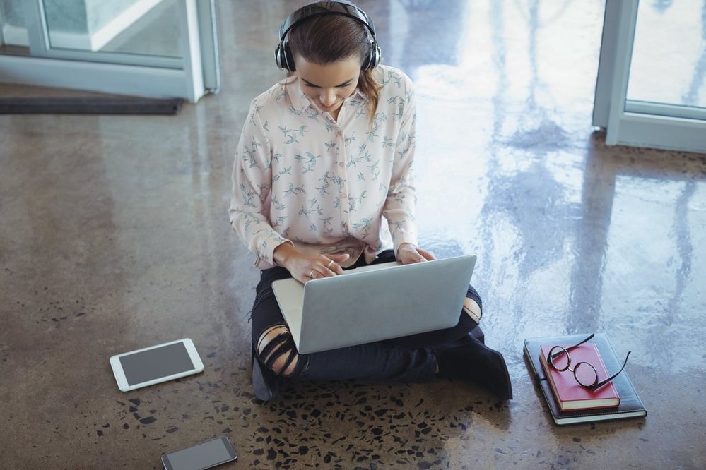Woman sitting on the floor working on a laptop