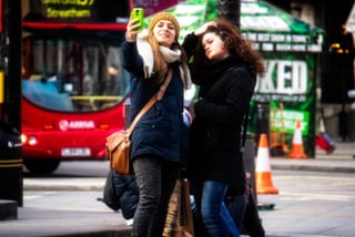 Marketing to Millennials: two girls taking a selfie in the street
