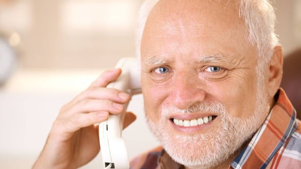 old man on the phone grimacing