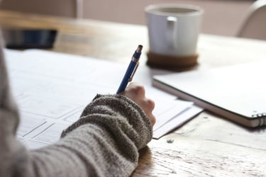 person sitting a table writing