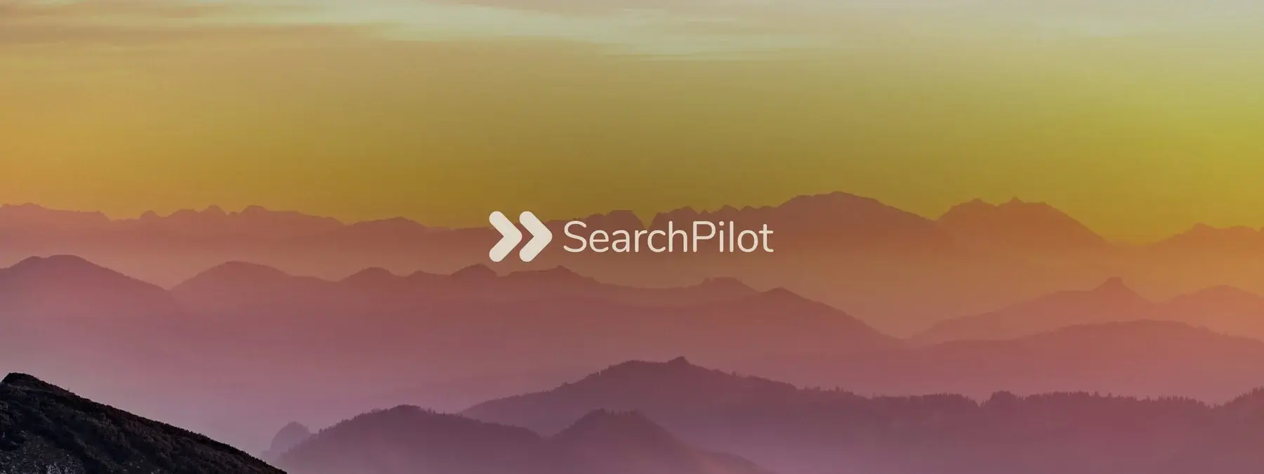 The SearchPilot logo on a pastel coloured image of mountains in the background.