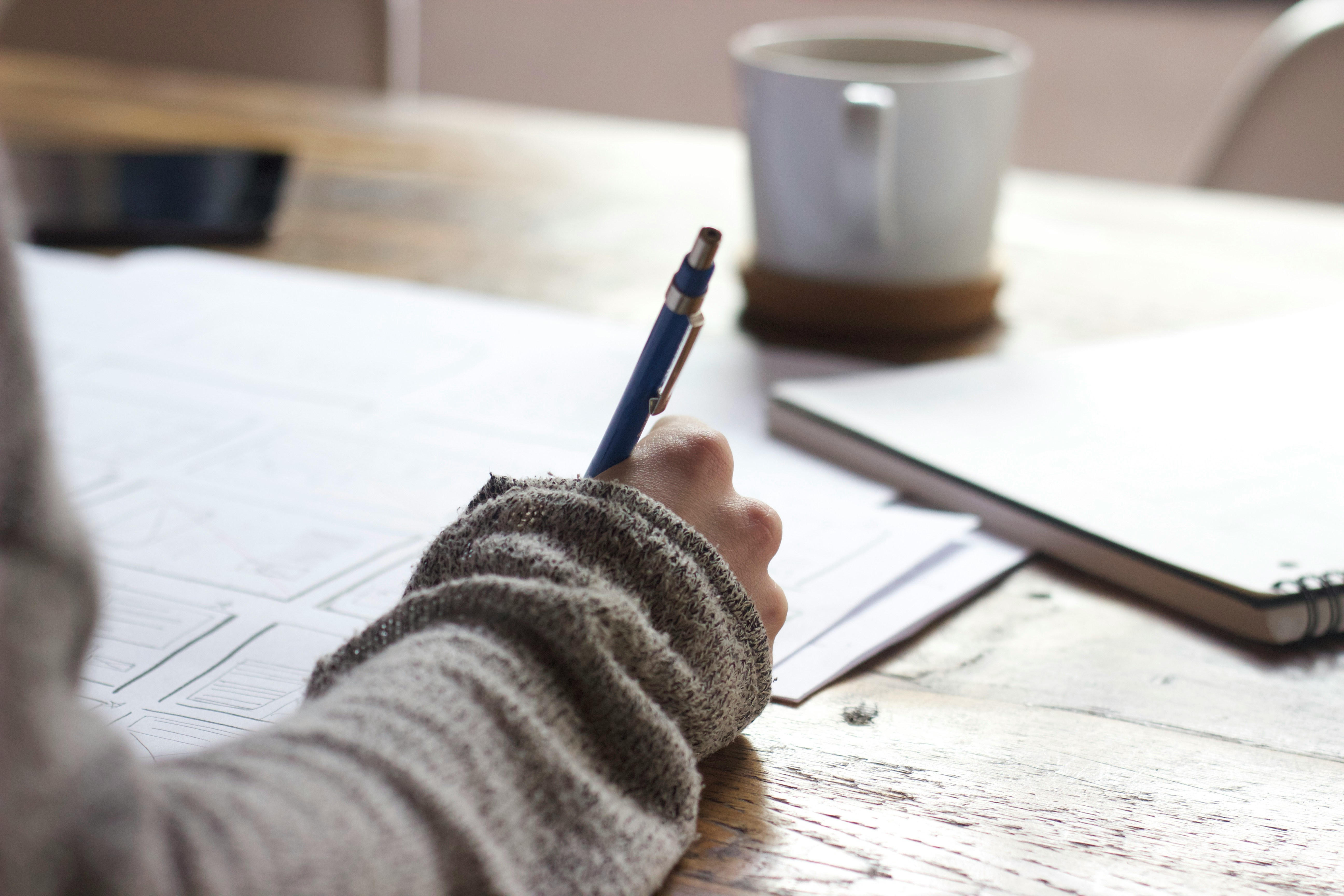 person sitting a table writing